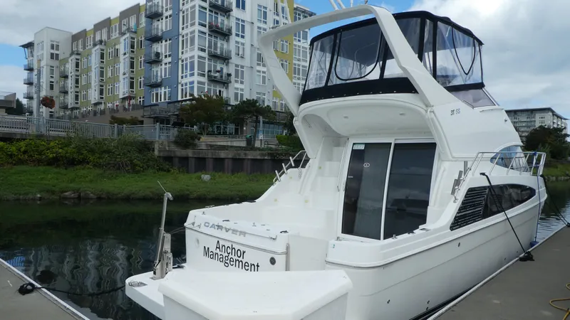 Slide: The Image of 2005 Carver 38 Super Sport yacht docked near modern apartments. - 2