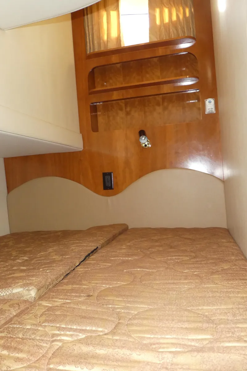 Slide: The Image of Interior cabin of 2005 Carver 38 Super Sport with wooden accents and beige bedding. - 22