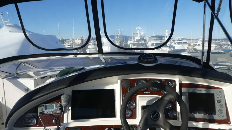 Slide: The Image of 2005 Carver 38 Super Sport helm with marina view, featuring navigation equipment. - 28