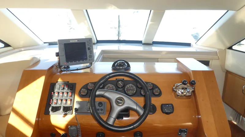 Slide: The Image of 2005 Carver 38 Super Sport helm with steering wheel and navigation controls. - 9