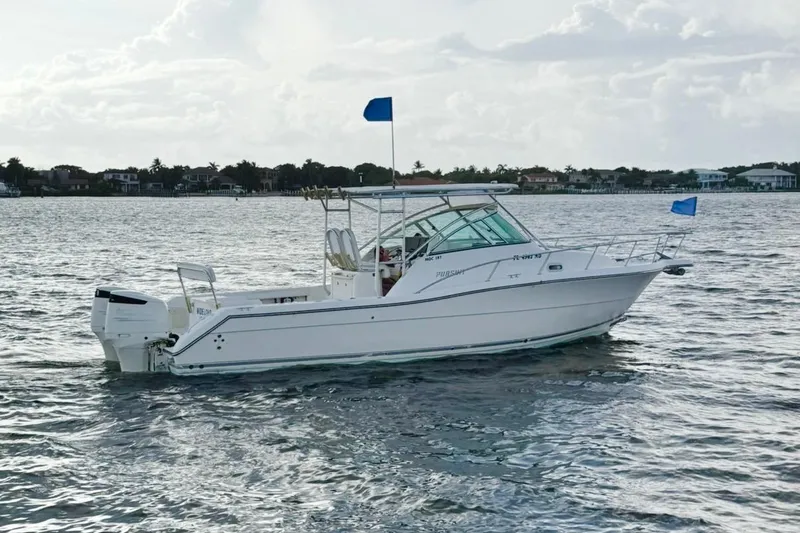 The Image of 2003 Pursuit 3070 Offshore Center Console boat on calm waters, blue flags flying. - 0
