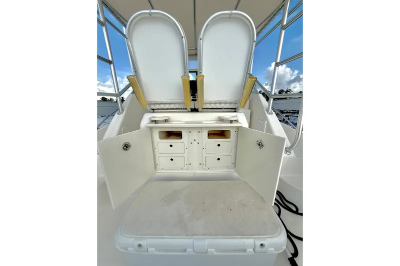 Slide: The Image of 2003 Pursuit 3070 Offshore Center Console boat storage compartments open under seats. - 12