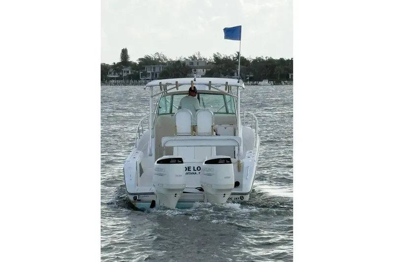 Slide: The Image of 2003 Pursuit 3070 Offshore Center Console boat on water, rear view with dual engines. - 5