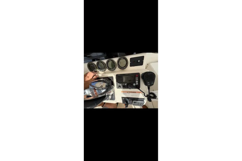 Slide: The Image of Control panel of 2003 Pursuit 3070 Offshore Center Console boat with gauges and radio. - 9