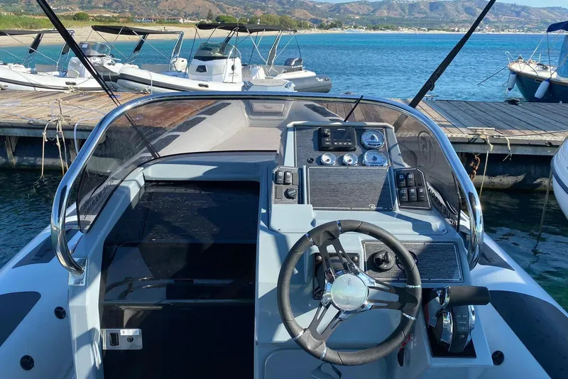 Slide: The Image of Cockpit view of 2022 Ranieri CAYMAN 27.0 SPORT TOURING boat docked by the sea. - 11