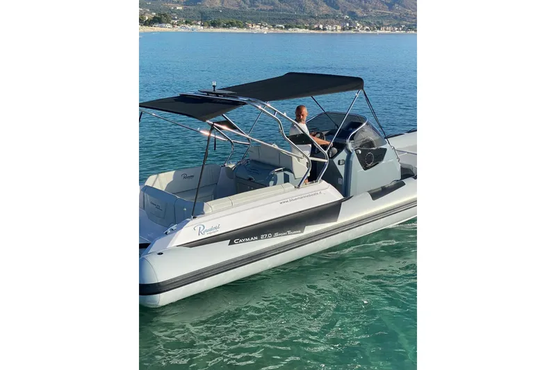 Slide: The Image of 2022 Ranieri CAYMAN 27.0 SPORT TOURING boat on clear blue water. - 27