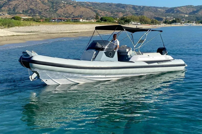 Slide: The Image of 2022 Ranieri CAYMAN 27.0 SPORT TOURING boat on clear blue water near a sandy beach. - 7