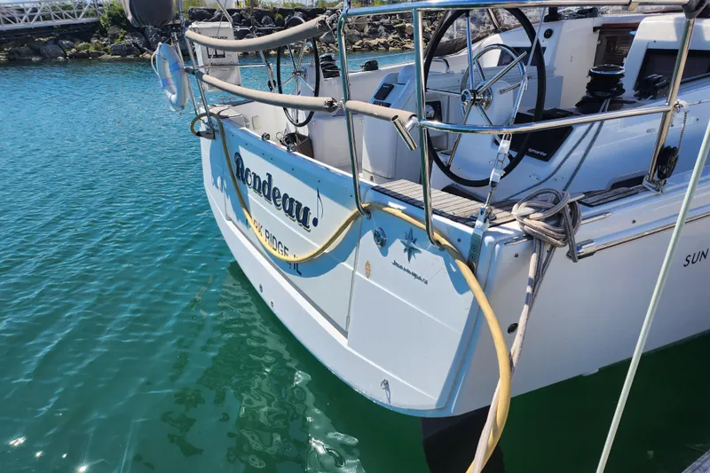 Slide: The Image of Jeanneau Sun Odyssey 410 sailboat docked, showcasing steering wheel and deck details. - 10