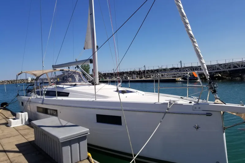 Slide: The Image of 2020 Jeanneau Sun Odyssey 410 sailboat docked at a marina under clear blue skies. - 2