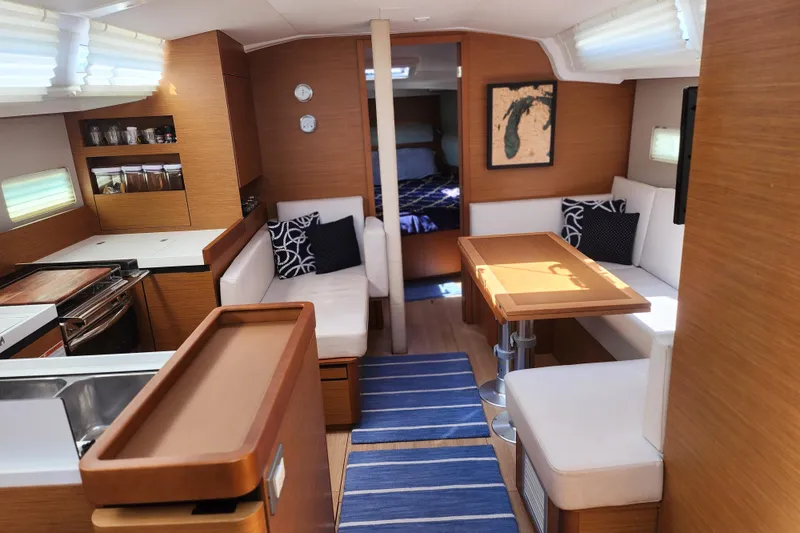 Slide: The Image of Interior of 2020 Jeanneau Sun Odyssey 410 sailboat with modern wood finish and cozy seating. - 20