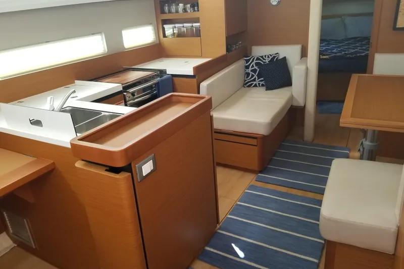 Slide: The Image of Interior of 2020 Jeanneau Sun Odyssey 410 yacht with modern kitchen and seating area. - 21