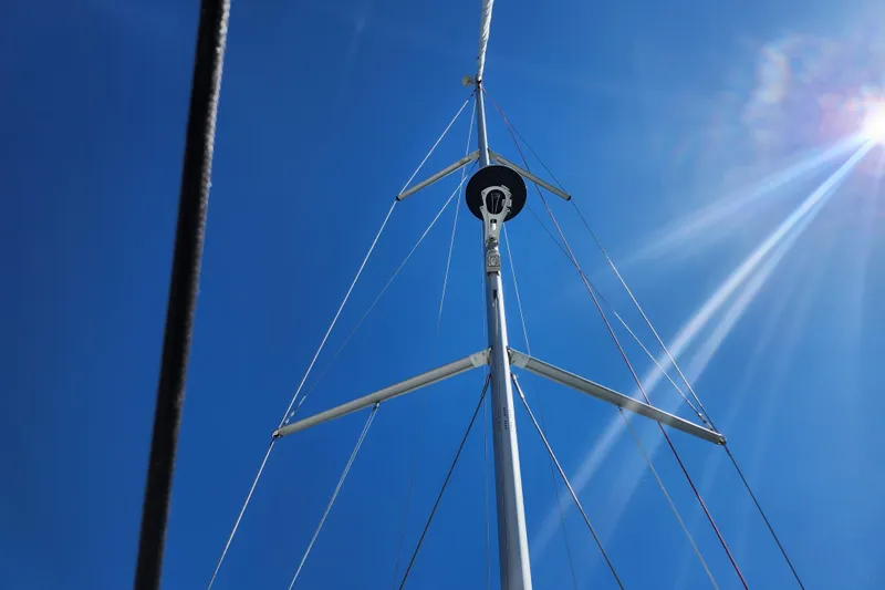 Slide: The Image of Mast of Jeanneau Sun Odyssey 410 sailboat against clear blue sky, 2020 model. - 9