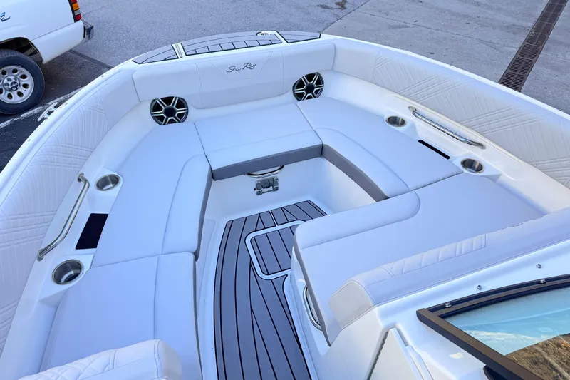 Slide: The Image of 2026 Sea Ray SDX 230 boat interior with white seating and cup holders. - 9
