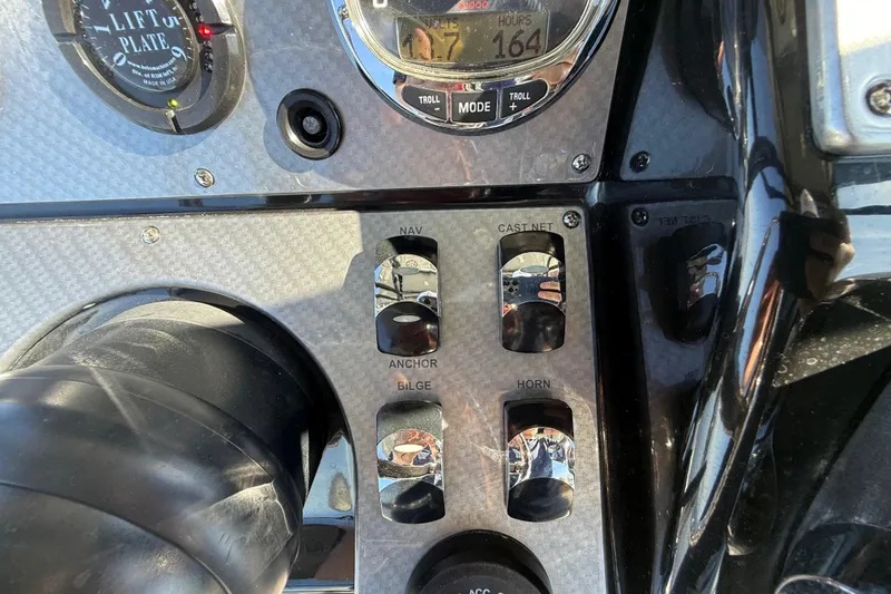 Slide: The Image of Control panel of a 2018 ShearWater 23LTZ boat with various switches and gauges. - 15