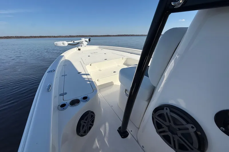Slide: The Image of 2018 ShearWater 23LTZ boat on calm water, showcasing sleek design and spacious deck. - 17