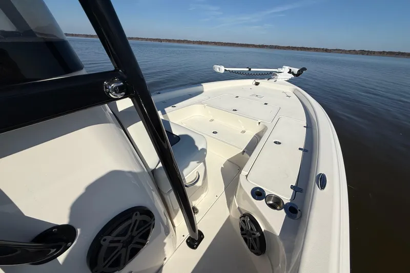 Slide: The Image of 2018 ShearWater 23LTZ boat on calm water, showcasing deck and seating area. - 19