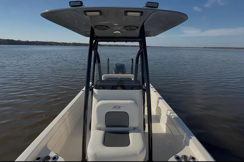 Slide: The Image of 2018 ShearWater 23LTZ boat on calm water under clear blue sky. - 24