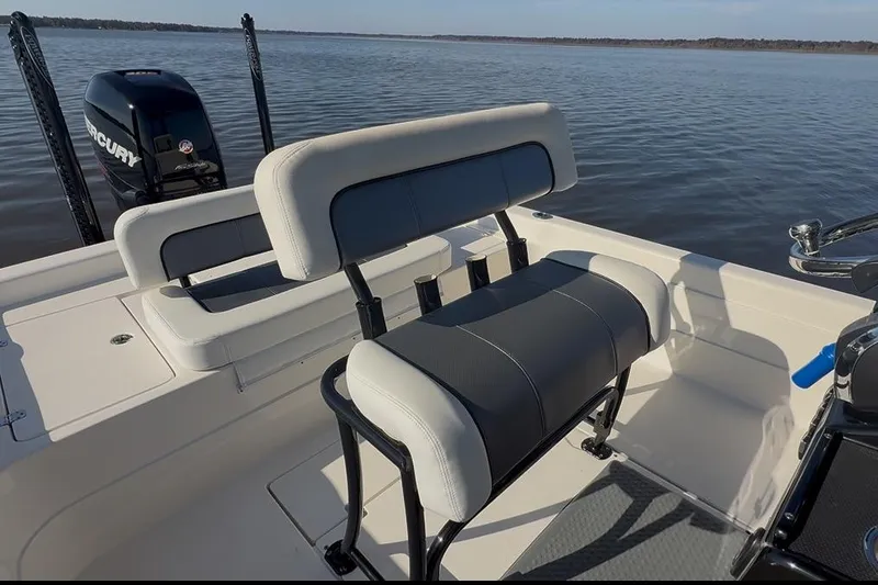 Slide: The Image of 2018 ShearWater 23LTZ boat interior with seating and Mercury engine on a calm lake. - 28