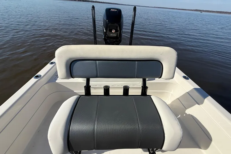 Slide: The Image of 2018 ShearWater 23LTZ boat interior with cushioned seating and outboard motor on calm water. - 29