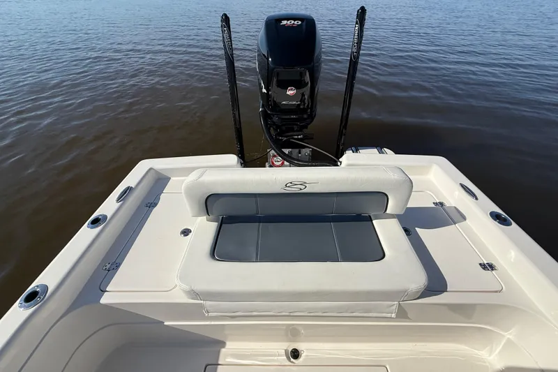Slide: The Image of 2018 ShearWater 23LTZ boat with cushioned seating and powerful outboard motor on calm water. - 30