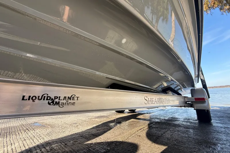 Slide: The Image of 2018 ShearWater 23LTZ boat on Liquid Planet Marine trailer by the water. - 37