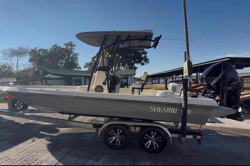 Slide: The Image of 2018 ShearWater 23LTZ boat on trailer, parked outdoors under clear sky. - 4