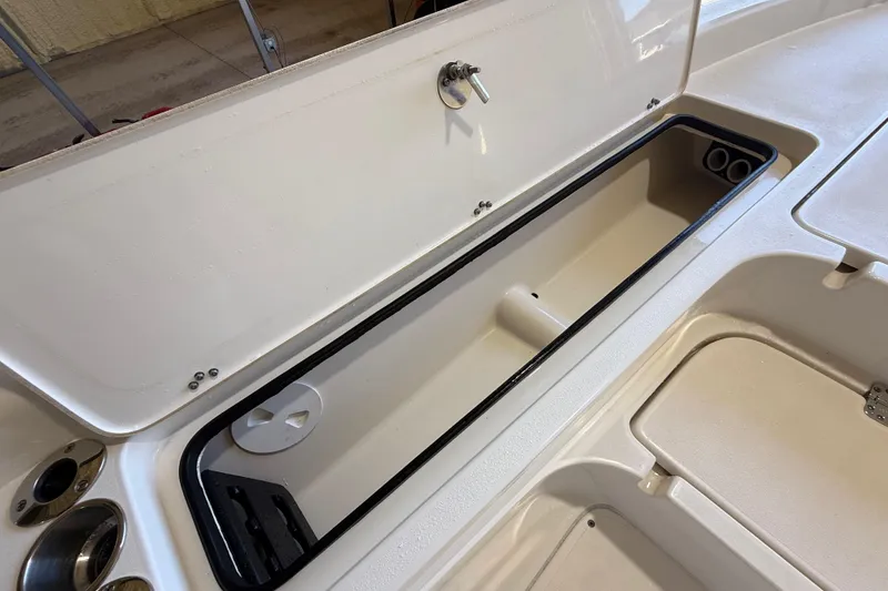 Slide: The Image of 2018 ShearWater 23LTZ boat storage compartment with open lid, showcasing interior features. - 48