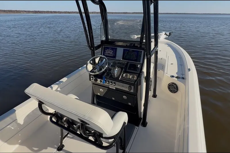 Slide: The Image of 2018 ShearWater 23LTZ boat interior with steering console on calm water. - 5