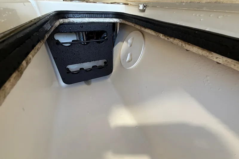 Slide: The Image of Interior view of a 2018 ShearWater 23LTZ boat compartment with black panel and white surface. - 50