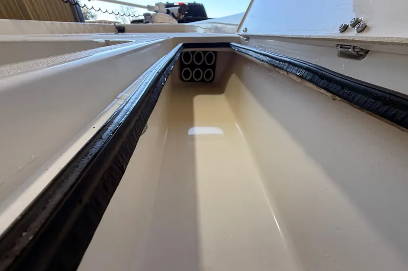 Slide: The Image of 2018 ShearWater 23LTZ boat storage compartment with rod holders. - 53