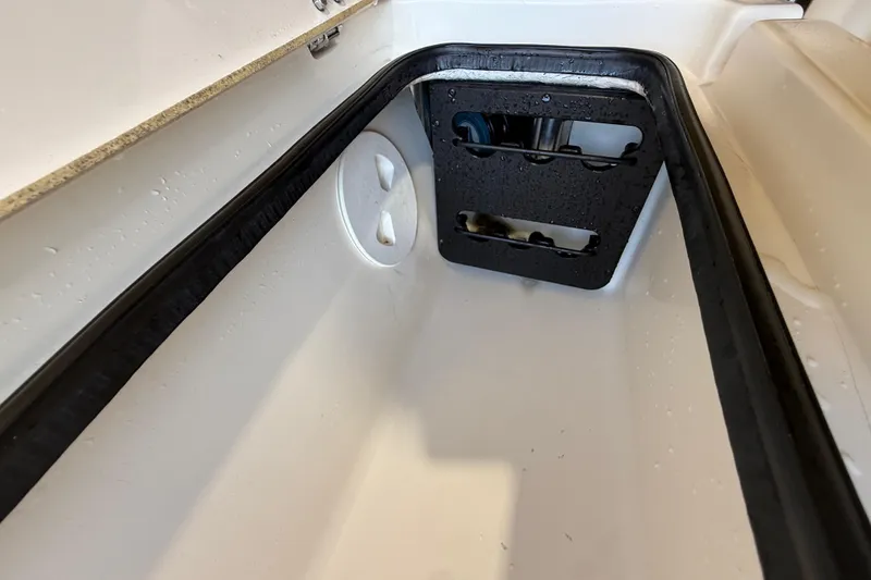 Slide: The Image of Interior compartment of 2018 ShearWater 23LTZ boat, featuring drainage and storage elements. - 54