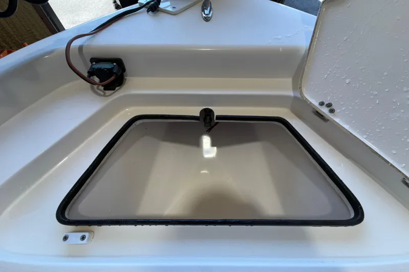 Slide: The Image of Open storage compartment on 2018 ShearWater 23LTZ boat, showing interior details. - 56