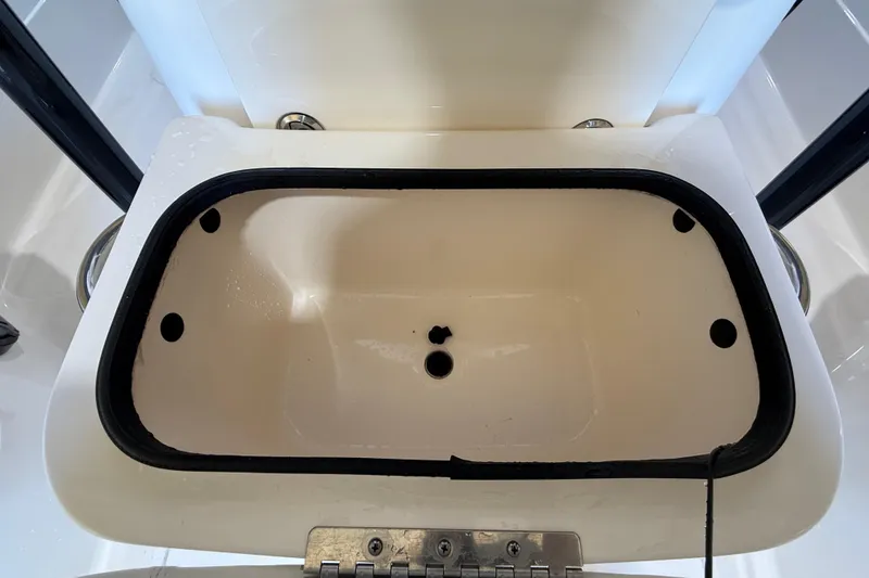 Slide: The Image of Livewell compartment on a 2018 ShearWater 23LTZ boat, featuring a white interior. - 58