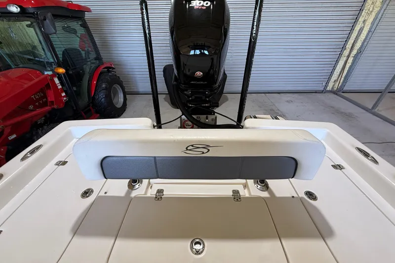 Slide: The Image of 2018 ShearWater 23LTZ boat with powerful engine, parked indoors near red tractor. - 61