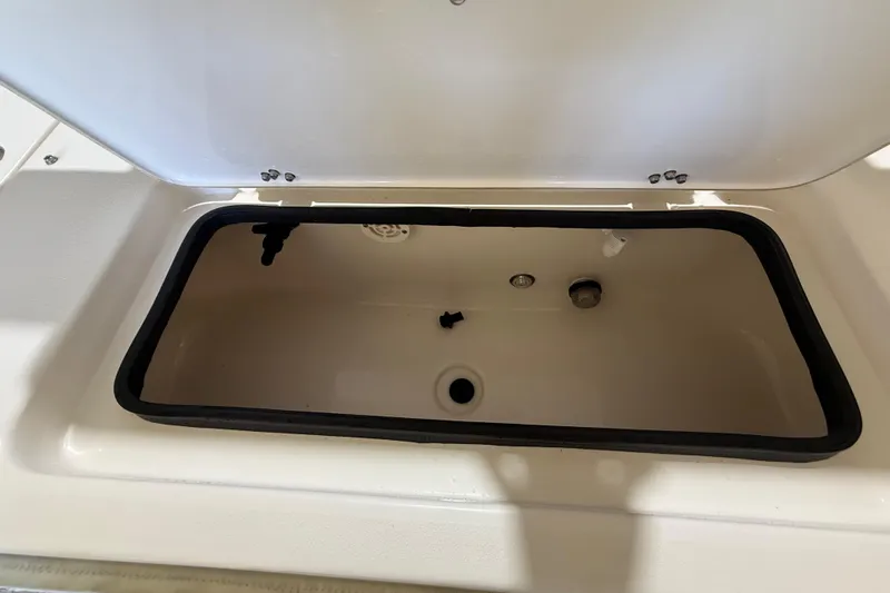 Slide: The Image of Open storage compartment on 2018 ShearWater 23LTZ boat, showing interior details. - 62