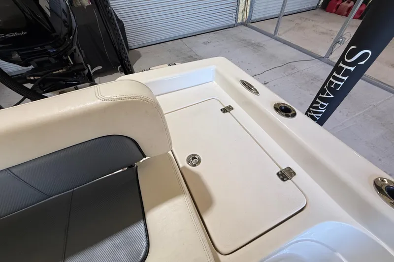 Slide: The Image of 2018 ShearWater 23LTZ boat interior with seating and storage compartment. - 63