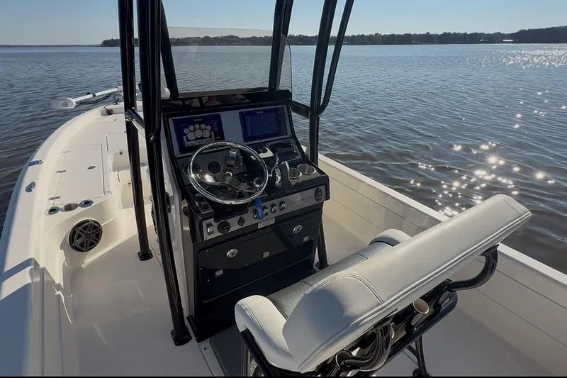 Slide: The Image of 2018 ShearWater 23LTZ boat interior with steering console on a sunny day. - 7