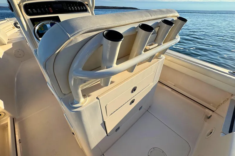Slide: The Image of 2024 Grady-White Fisherman 216 boat interior with rod holders and console, on calm water. - 12