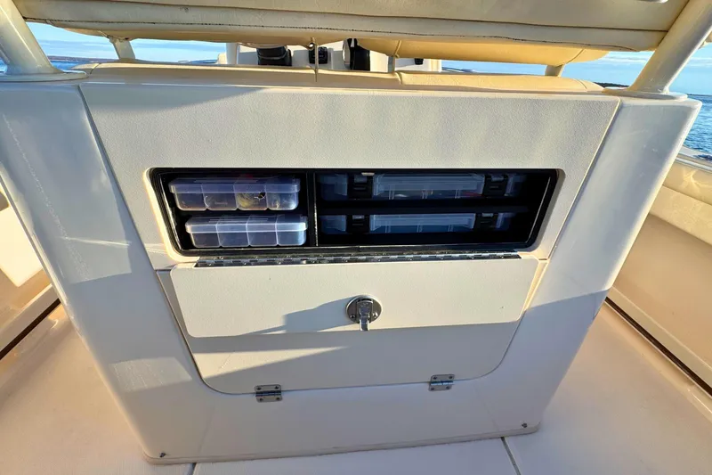 Slide: The Image of 2024 Grady-White Fisherman 216 boat storage compartment with tackle boxes and secure latch. - 15