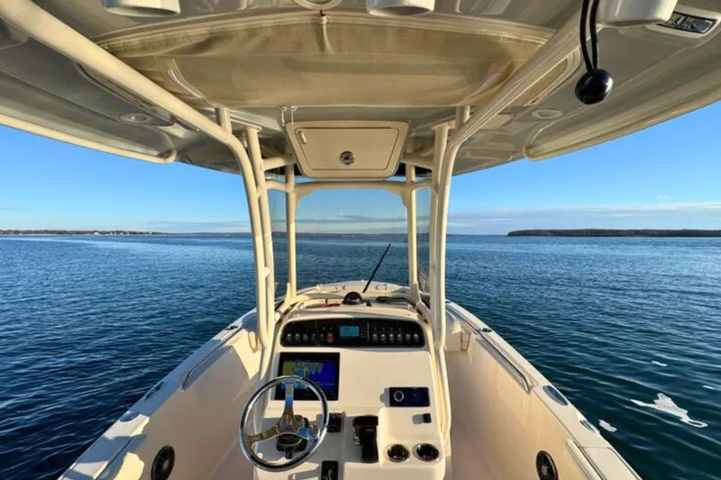 Slide: The Image of 2024 Grady-White Fisherman 216 boat on calm blue water, showcasing helm and console. - 16