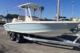 The Image of 2024 Boston Whaler 220 Dauntless boat on trailer, parked outdoors under clear blue sky. - 0