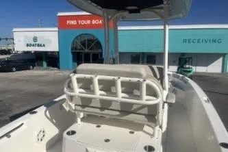 Slide: The Image of 2024 Boston Whaler 220 Dauntless boat at dealership, showcasing seating and console. - 6