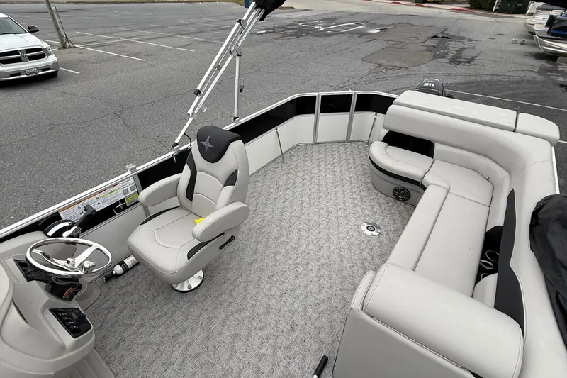 Slide: The Image of 2025 Berkshire 24CL 2.75 LE pontoon boat interior with plush seating and steering console. - 7