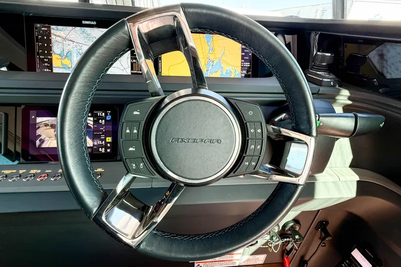 Slide: The Image of Steering wheel of 2024 Axopar 45 XC Cross Cabin with navigation displays. - 17