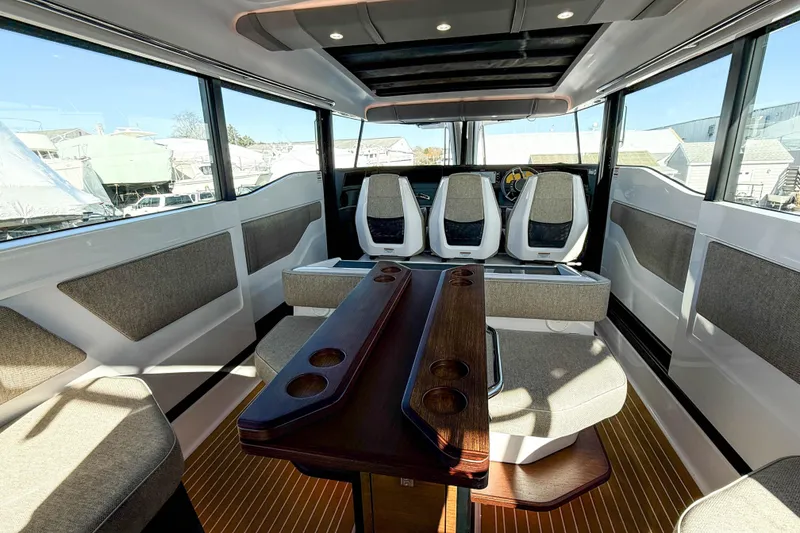 Slide: The Image of 2024 Axopar 45 XC Cross Cabin interior with modern seating and wooden table. - 24