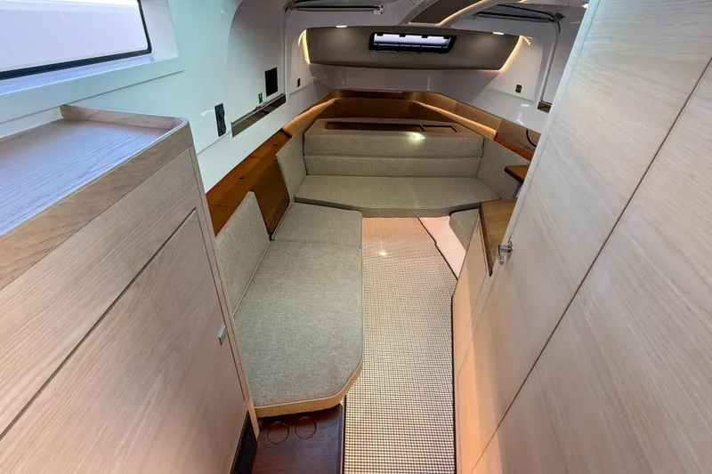 Slide: The Image of 2024 Axopar 45 XC Cross Cabin interior with modern seating and wood finishes. - 25