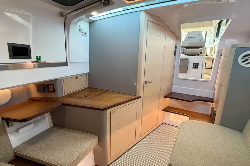 Slide: The Image of 2024 Axopar 45 XC Cross Cabin interior with modern wood and fabric finishes. - 28