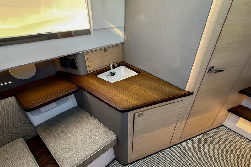 Slide: The Image of 2024 Axopar 45 XC Cross Cabin interior with compact sink and seating area. - 29