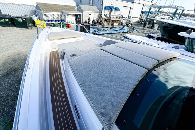 Slide: The Image of 2024 Axopar 45 XC Cross Cabin with cushioned deck, docked at a marina. - 35