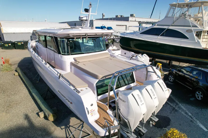 Slide: The Image of 2024 Axopar 45 XC Cross Cabin boat with triple Mercury engines, docked at a marina. - 4